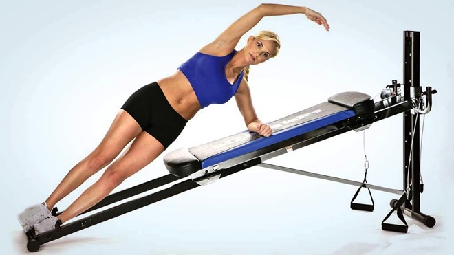 woman doing side plank on exercise machine